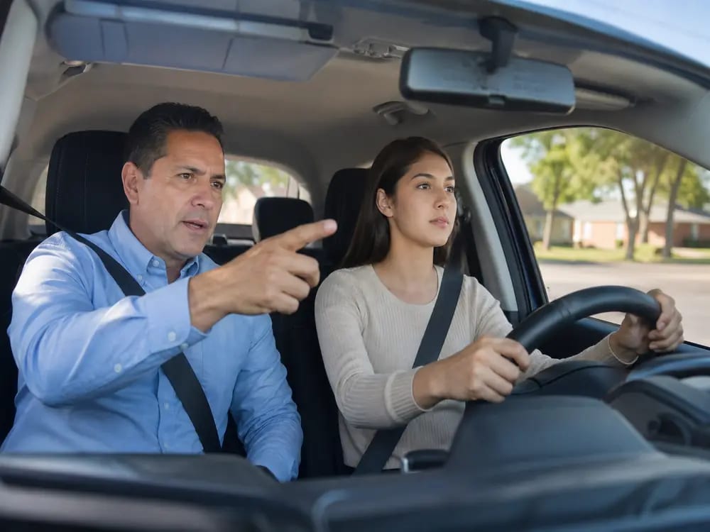 State-certified instructor coaching a student during an in-car driving lesson in Dallas